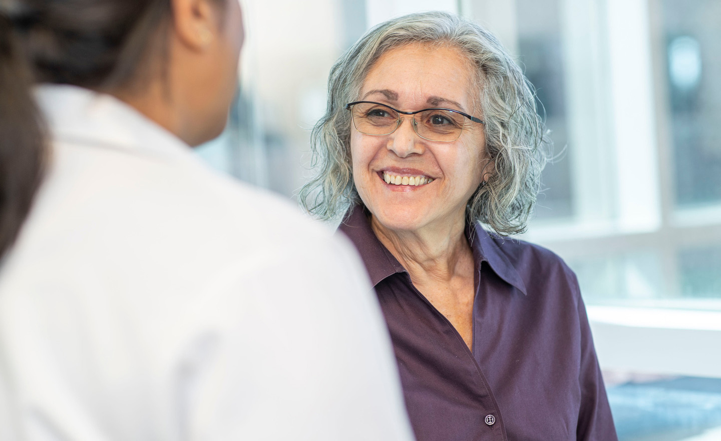 Patient looking up at her doctor and smiling