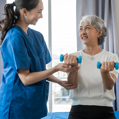 Cancer provider working with patient on physical therapy hand and arm exercises